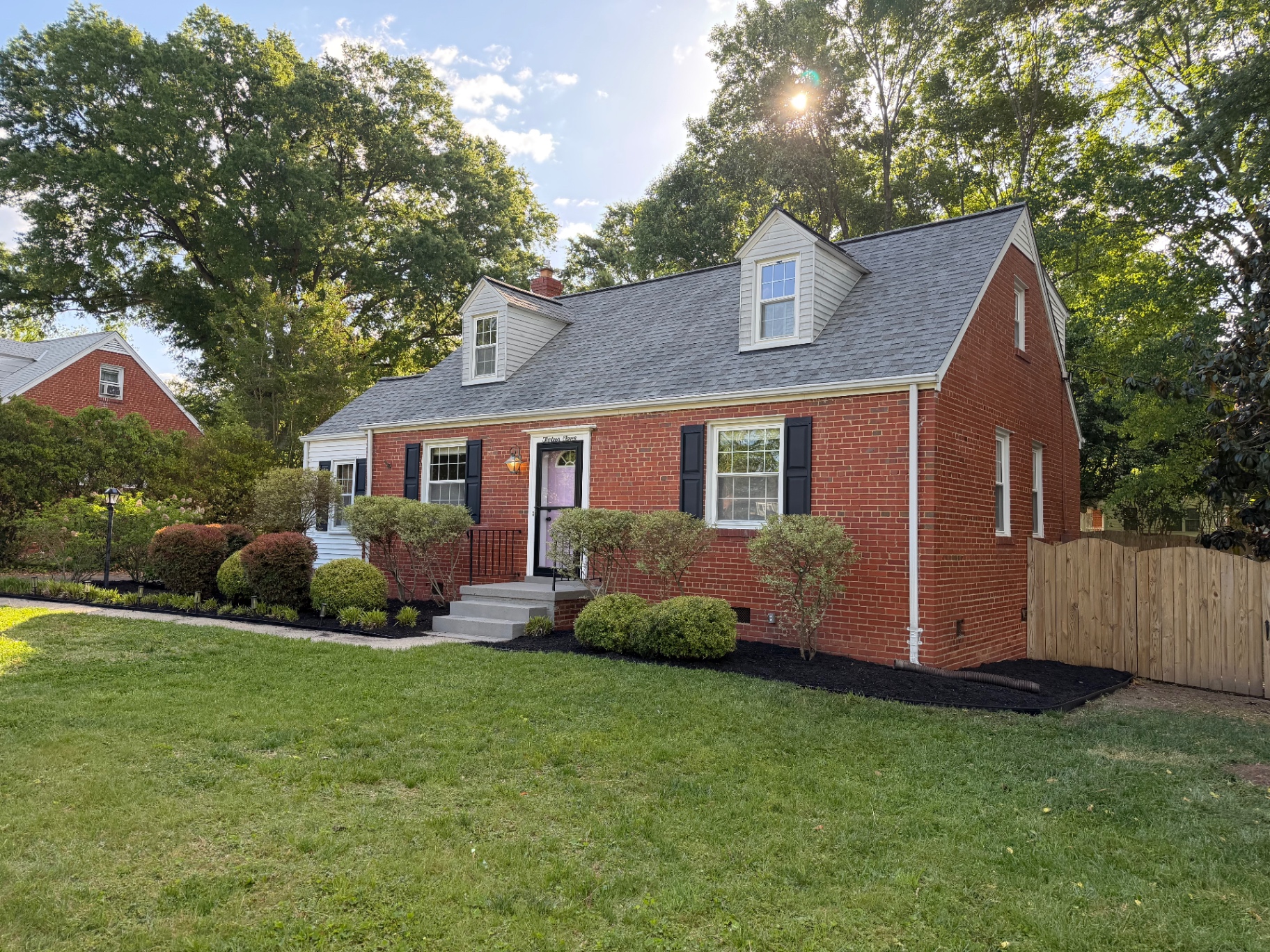Red brick home with refreshed foundation landscaping and crisp black mulch beds