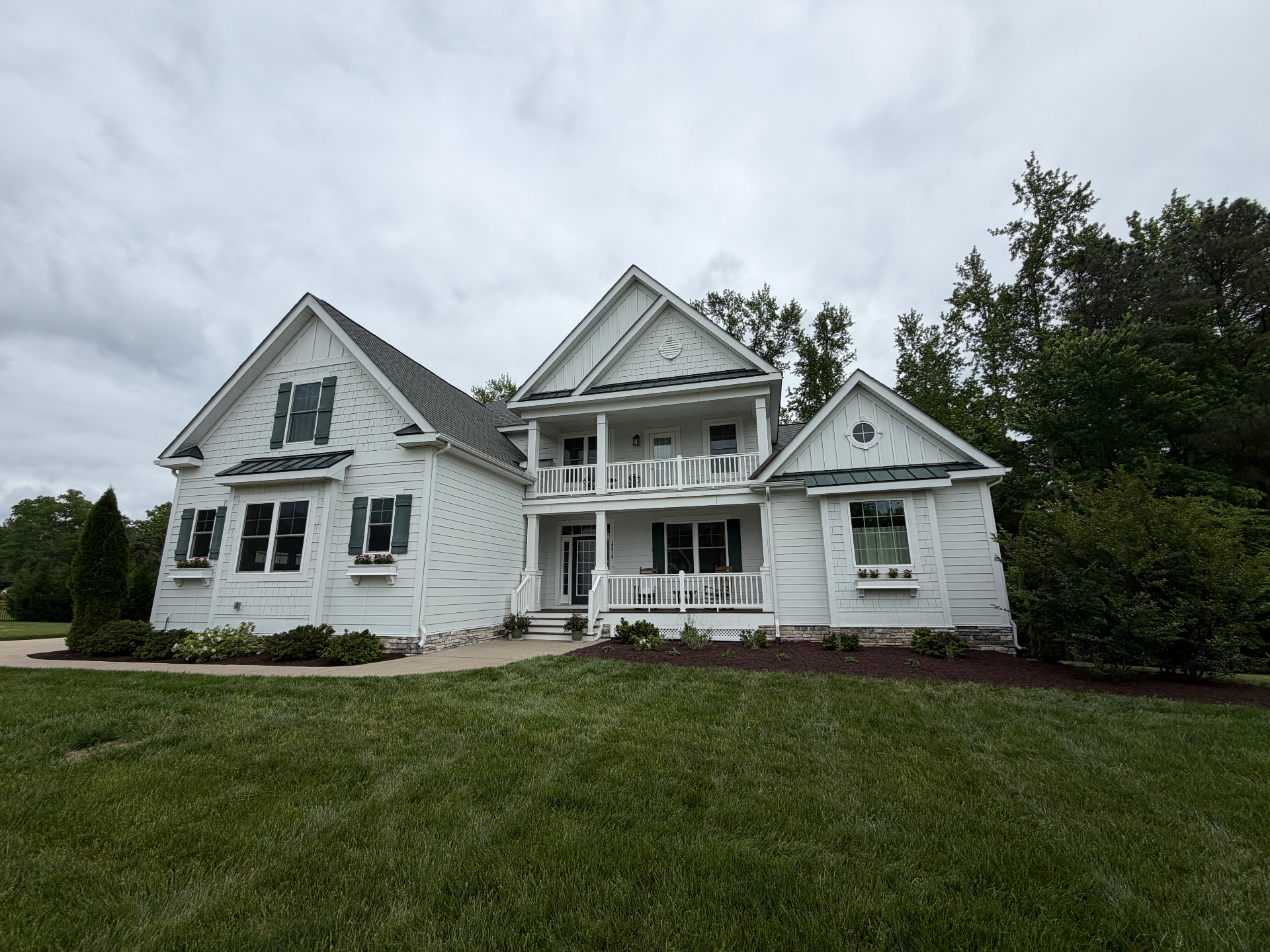 Manicured front lawn at a custom white farmhouse